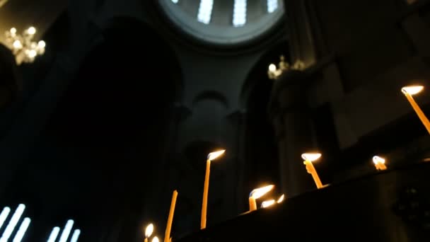 Interno scuro di un gran tempio - movimento di macchina fotografica dal basso su. Candele e cupola luminosa Chiesa ortodossa — Video Stock