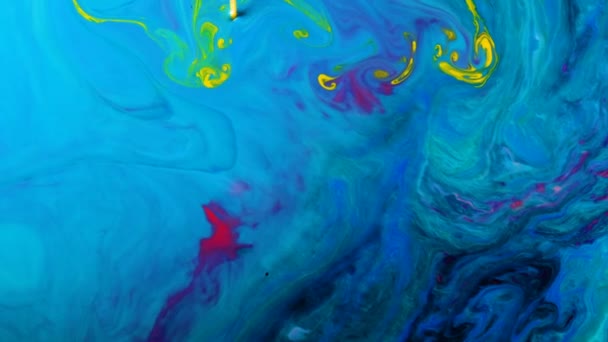 Les colorants psychédéliques jaunes sont mélangés dans des motifs abstraits dans un liquide bleu — Video