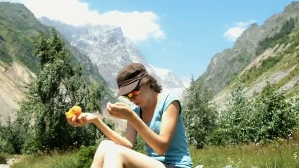 Vrouw Zit Een Steen Eet Een Perzik Een Achtergrond Van — Stockvideo