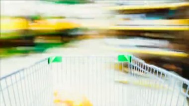 Hızlandırılmış hız arabası alışveriş süpermarkete sürmek ve raf ve alıcılar bulanık yiyecekle dolu