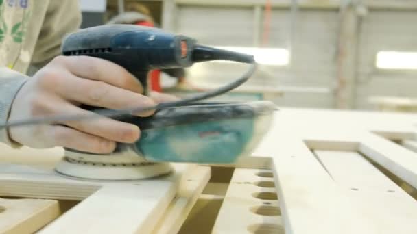 Handen van schrijnwerker-timmerman slijpen houten plank met behulp van machine — Stockvideo