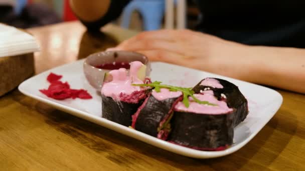 Frau in einem vegetarischen Restaurant isst Rohkost-Brötchen, Nahaufnahme — Stockvideo