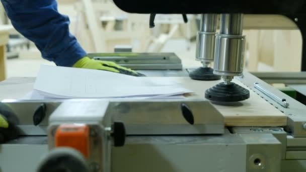Carpinteiro funciona em uma máquina de perfuração. Envolvido na produção de móveis de madeira — Vídeo de Stock