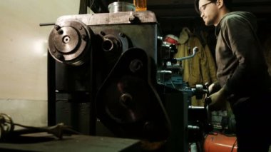 Turner, metal konstrüksiyon fabrikasında bir torna tezgahı üzerinde çalışıyor. Metal endüstrisi. Bir Kaliper ile önlemler