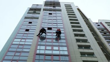 Erkekler yıkama pencereleri, yıkama bir gökdelenin üzerinde bir dağcı çalışmak