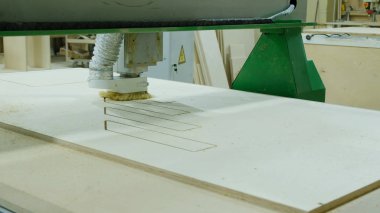 Modern ağaç işleme makinesi içinde hareket. Kontrplak levha kıvırcık parçalar keser. Ahşap mobilya