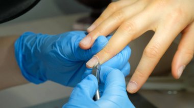 Şevval Özçelik Güzellik kırpma cuticles kadın istemci. Manikür ve cilt bakımı. Spa Güzellik Salonu kadında. Elinde yakın çekim.