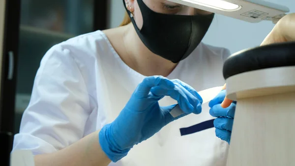 Manicure em processo de trabalho. Remoção de verniz antigo e limpeza de unhas com arquivo de unhas — Fotografia de Stock