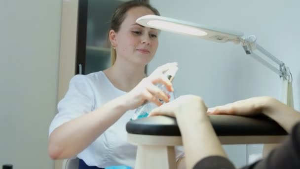 Manicurer maneja las manos con un antiséptico antes de realizar una manicura. Salón de belleza, cuerpo  . — Vídeo de stock