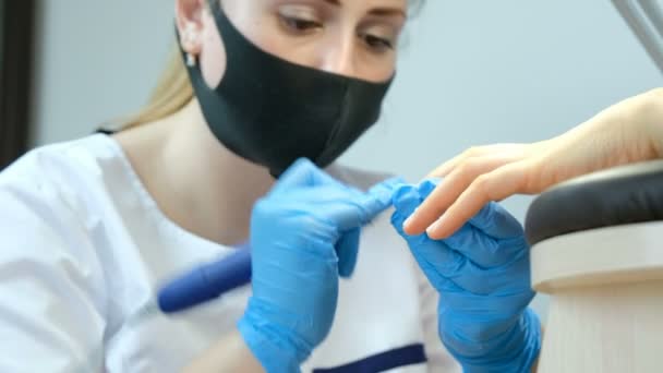 La manicura pule la cutícula con un cortador de silicona. Tratamiento y cuidado de uñas en un salón de belleza . — Vídeos de Stock