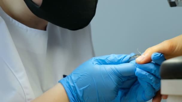 Manicurista che lavora con pinza per cuticole. Cura delle unghie e rimozione delle cuticole in un salone di bellezza. Processo di fabbricazione di manicure . — Video Stock