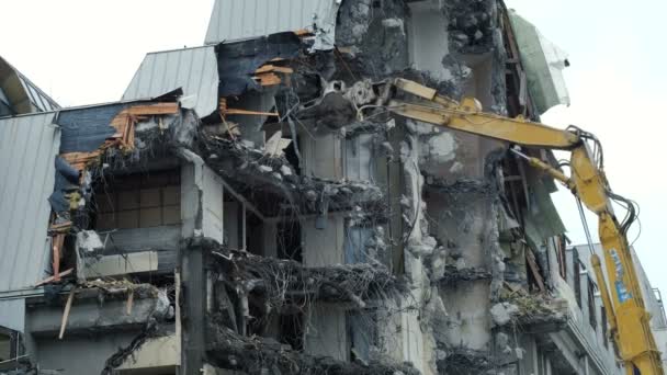 L'excavatrice détruit l'ancien bâtiment. Travaux de démolition, chutes de béton et d'armature — Video