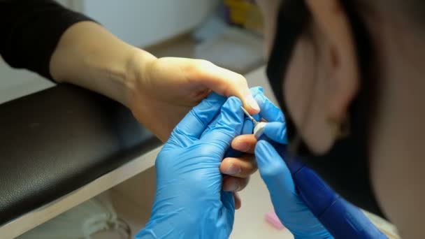 En manikyr polerar nagelbanden med en silikon-fräs. Vård och behandling av naglar i en skönhetssalong. — Stockvideo