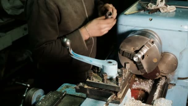 Turner works on a lathe, grinds the metal part and checks the dimensions of the caliper — Stock Video