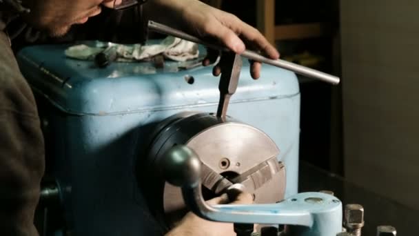Turner sécurise la pièce métallique dans trois mandrin à came pour son traitement. Tourner le travail dans l'atelier . — Video