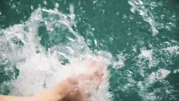 Womens benen spartelen helder water in slow motion, spatten van water in de zon te vliegen — Stockvideo