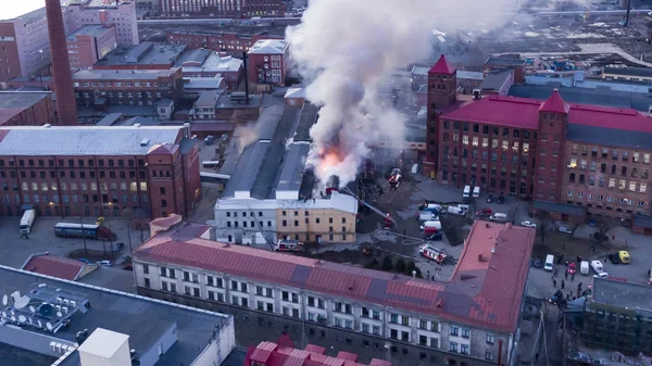 Brandweerlieden blussen een brandend gebouw, luchtfoto — Stockfoto