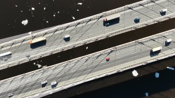 Luftaufnahme von Lastwagen und Autos, die auf einer Schrägseilbrücke über den Fluss fahren — Stockvideo