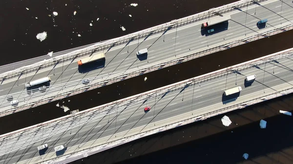 Vista aérea de caminhões e carros que dirigem em uma ponte por cabo sobre o rio — Fotografia de Stock