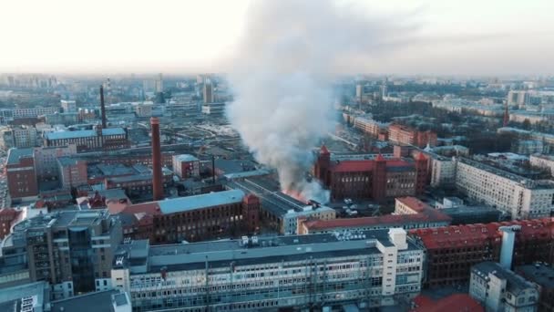 Luchtfoto van een brand in het gebouw, brandweer blussen het vuur. Het dak van het huis in vlammen, is er zwarte rook. — Stockvideo