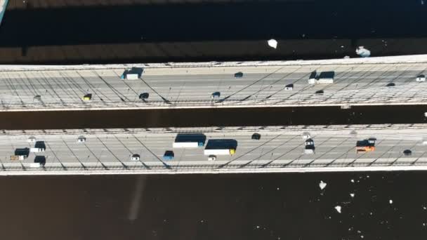 Prise de vue aérienne avec rotation au-dessus du pont suspendu par câble au-dessus de la rivière, voitures conduisant sur la route 