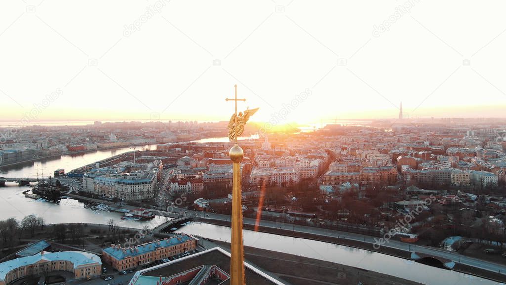 The span of the angel on the steeple in the Peter and Paul Fortress at sunset - aerial shooting of the historical center of St. Petersburg