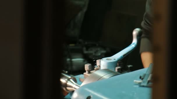 Man in glazen werkt en houdt metalen draaibank blauw handvat — Stockvideo