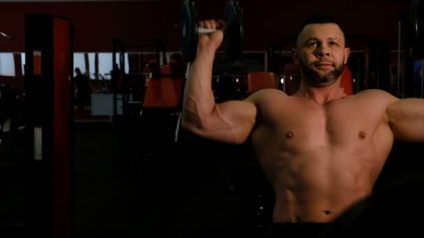 Movimiento pasado hombre desnudo con grandes bíceps ejercitando mancuerna — Vídeo de stock