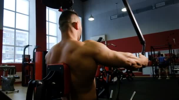 Athletischer Typ trainiert Arm- und Brustmuskulatur an Fitnessgerät