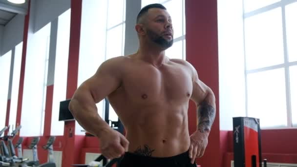 Homme bronzé avec de gros biceps joue avec les muscles et pose — Video