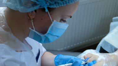 pedikür ustası ayak ayak tutar ve hafifçe çivi keskinleştirir