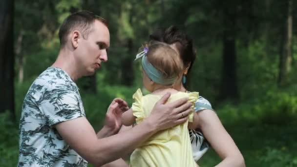 Jovem família feliz com uma criança caminha na floresta — Vídeo de Stock