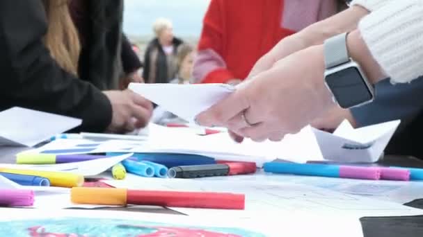 Руки людини з сучасним розумним годинником роблять паперовий човен — стокове відео
