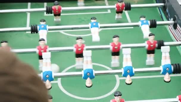 Människor spelar bordsfotboll med röda och blå spelare — Stockvideo