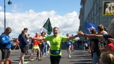 30 Haziran 2019 St. Petersburg: Mutlu maraton koşucuları, insanların koridoru boyunca mesafenin son kilometrelerini koşarlar ve beşlik çak