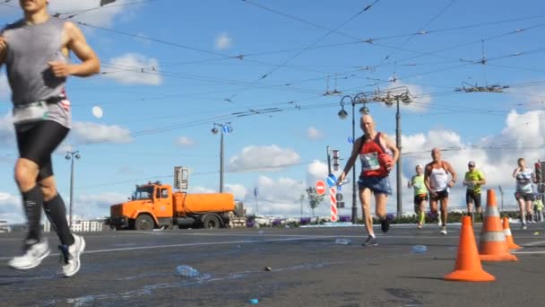 2019년 6월 30일 상트페테르부르크: 마라톤 주자가 거리를 달리고 물, 물 자체, 플라스틱 병 던지기 로 항목 후 물을 마십니다. — 비디오