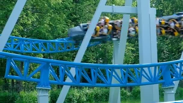 Les visiteurs du parc d'attractions conduisent le long des rails de montagnes russes — Video