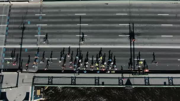 Sporty people run marathon along grey road in summer — Stock Video