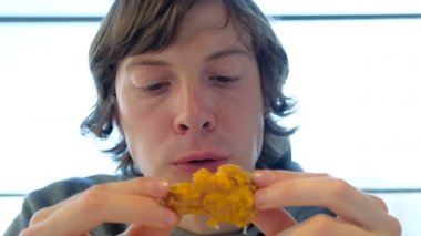 yakışıklı adam modern fastfood restoranda tavuk yiyor