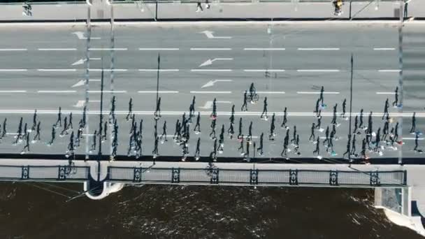 Active sportsmen run summer marathon along bridge aerial — Stock Video