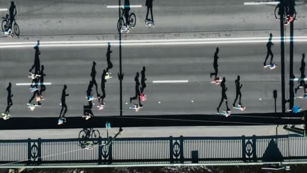 Sporcular kalabalık trafik olmadan gri yol boyunca maraton koşmak — Stok video