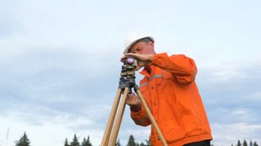 yetenekli eksper kahverengi ahşap tripod üzerinde dumpy seviyesi giderir