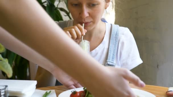 Číšník přináší čerstvý chutný salát dámě na pití hladkých — Stock video