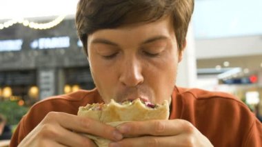 konsantre adam iştah açıcı falafel ile lavaş çiğner ve bir peçete yakın çekim ile ağzını siler