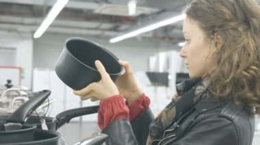 mavi gözlü kız bir hırdavatçı bir tavada bir tava seçer