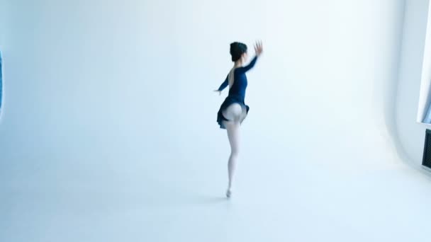 Молодая балерина исполняет балетный танец на белой стене — стоковое видео