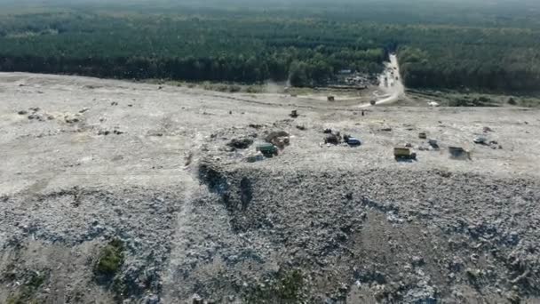 Vrachtwagens gooien onzin op vuilnis dump Hill tegen bos — Stockvideo