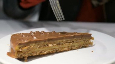 kişi kahverengi çikolatalı kek dilim gümüş çatal girişleri