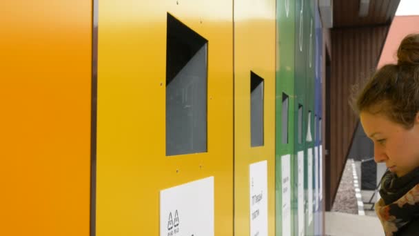 Brunette kastar plast sopor i gul återvinning container — Stockvideo