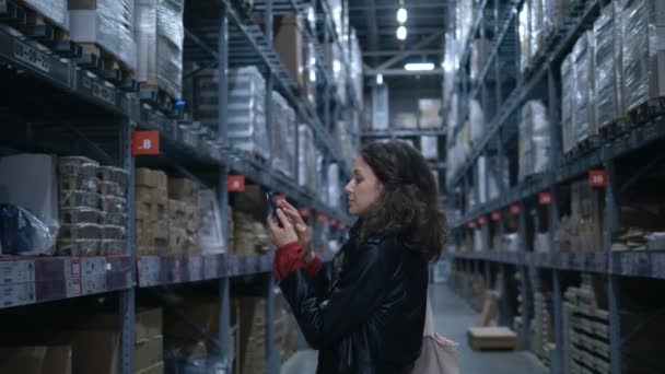 Jolie dame se tient dans un grand magasin à la recherche de marchandises — Video